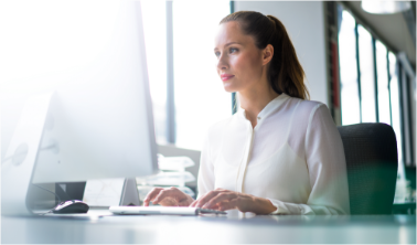 Lioton 1000® la locul de muncă, o femeie așezată la un birou lucrând la un computer într-un oficiu.