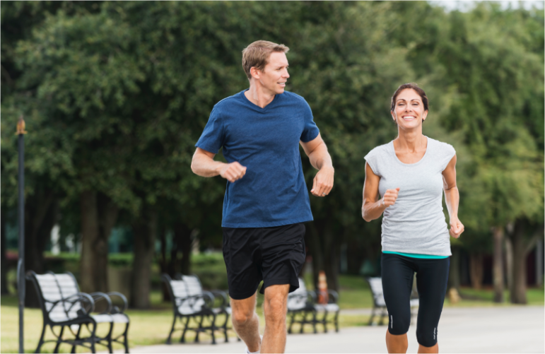 un cuplu bine dispus face jogging și râde în parc după ce a folosit Lioton 1000®