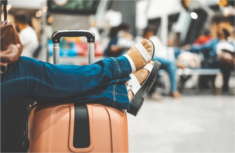 Lioton 1000® pentru călătorie, o persoană stă pe o bancă cu picioarele sprijinite pe un rucsac.